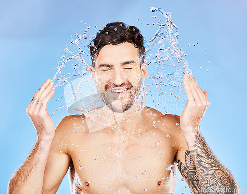 Image of Skincare, water and facial man beauty routine for grooming, hygiene and cleaning routine with smile. Wellness, water splash and health of happy skin model in blue studio with satisfied face.