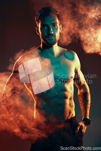 Image of Fitness, body and man in a studio with smoke or mist after an intense workout or bodybuilding training. Sports, health and portrait of a bodybuilder or athlete with muscle isolated by dark background