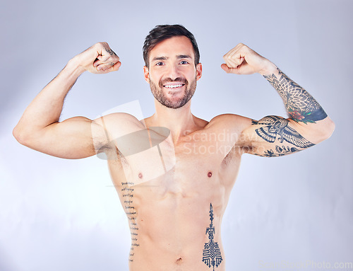Image of Bodybuilder, man and flex body, smile for wellness, after fitness and training with grey studio background. Muscles, arms and healthy man with motivation, workout and happy with progress and portrait