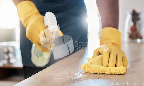 Image of Black man hands, spray bottle or cleaning cloth for wooden table or desk in house living room, home or office building. Zoom, cleaner or maid service with fabric product for bacteria hygiene wellness