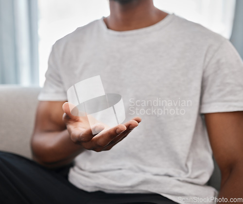 Image of Marketing, product placement and hands of a man advertising with palm on the sofa in a house lounge. Branding, logo and hand of a person to show a product in space while on the living room couch