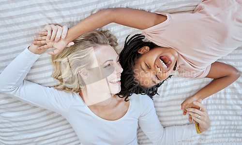 Image of Mother, girl and bed fun after adoption or foster with love and care in a bedroom with happiness. Family care, funny and happy time of a mama and child together with a smile, gratitude and laughing