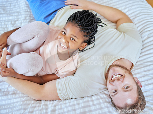 Image of Family, portrait and smile while on bed to relax, love and trust after adoption with father and foster child in home bedroom for quality time. Man and girl from top while bonding, happy and together