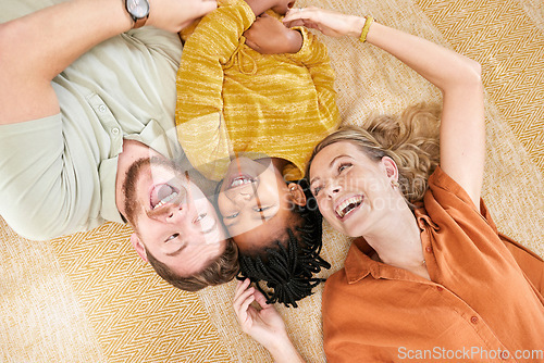 Image of Interracial family, adoption and home on floor with head together for love, happy and bonding. Mom, dad and african girl child lying with smile, happiness and diversity on carpet with top view