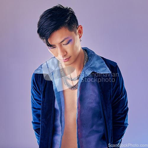 Image of Asian man, fashion and cyberpunk makeup aesthetic for futuristic beauty or vintage clothes. Retro, creative pop art gen z model and funky rock style with metal chain in purple background studio