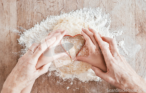 Image of .Hands, baking and heart shape with a girl and grandmother learning how to bake in the kitchen of their home together. Family, children and food with a woman and granddaughter bonder over cooking.