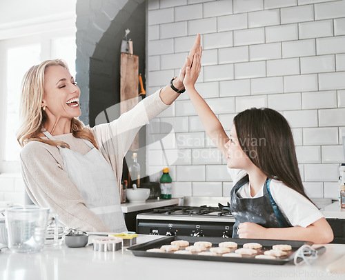 Image of .High five, kid and baking with mom for development, bonding and teaching of skills to bake in the kitchen. Cooking, cook and motivation of mother and daughter in the family home for culinary skills.