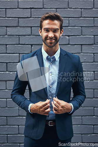 Image of Portrait businessman, suit and brick wall in city of Spain for corporate success, professional goals and expert management. Happy young manager, ceo and boss standing against urban background outdoor