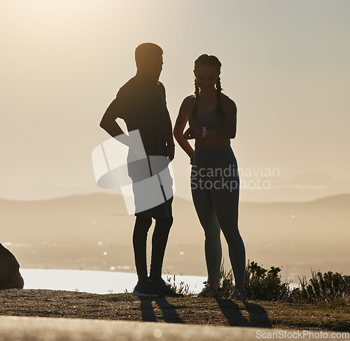 Image of Fitness, couple and checking time for running, exercise workout or sports training on a mountain in the outdoors. Man and woman silhouette in wellness for healthy run and monitoring performance