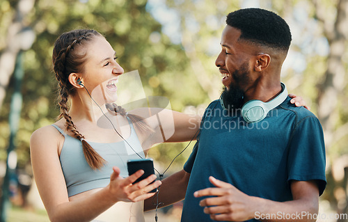 Image of Headphones, fitness and couple with phone in nature on break after workout, running or training. Sports, diversity and man and woman streaming music, radio or podcast outdoors on 5g mobile smartphone