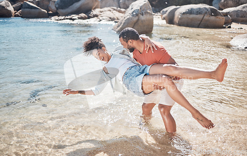 Image of Couple, love and man carrying woman on beach for funny, comic or relax travel adventure together. Happiness, support and african person carry wife, quality time in water for Hawaii summer vacation