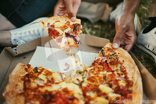 Image of Pizza, food and hands of a couple eating in a park, picnic and relax on an outdoor date together. Hungry, fast food and zoom of man and woman with lunch or dinner in nature for peace and calm