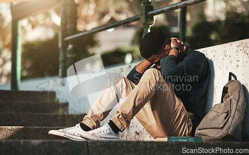 Image of Student, mental health and depression with anxiety, burnout and sad for exam results, fail or mistake while sitting outdoor. Young man, stress and tired and depressed on university or college campus