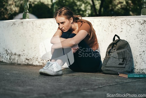 Image of University, sad and woman student sitting outside in depression for fail on education exam. College, depressed and upset female sit on floor outdoors upset about educational learning book