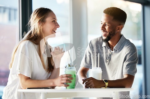 Image of Couple, drink and happy with talking, date and enjoy in shop, cafe or store with smile, happy and romance. Interracial man, woman or friends in funny conversation, communication and bonding together