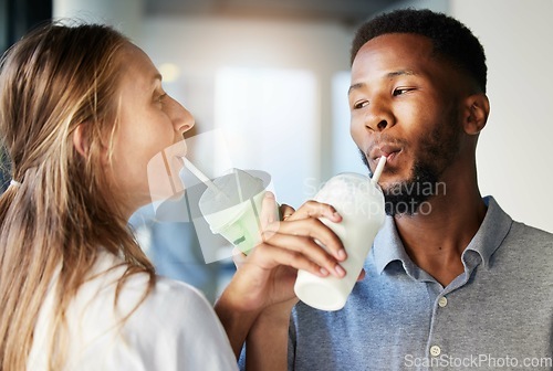 Image of Restaurant, date and couple drinking a milkshake together while at a romantic summer adventure. Happy, love and interracial man and woman enjoying a smoothie at a cafe or coffee shop in the city.