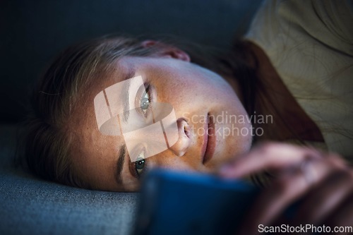 Image of Night, phone and young woman on sofa to check social media, browsing internet and online content. Technology, mobile app and girl with smartphone for texting, chatting and conversation lying on couch