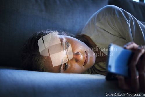 Image of Phone, night and sad woman relaxing on sofa in living room scrolling on social media after a break up. Depression, upset and girl on couch in lounge reading student loan or debt emails on smartphone.