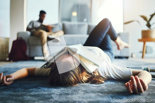 Image of Burnout, student and tired woman with book on her face for knowledge exhaustion and fatigue. College, university and problem with a female lying on the floor covered in a notebook for studying