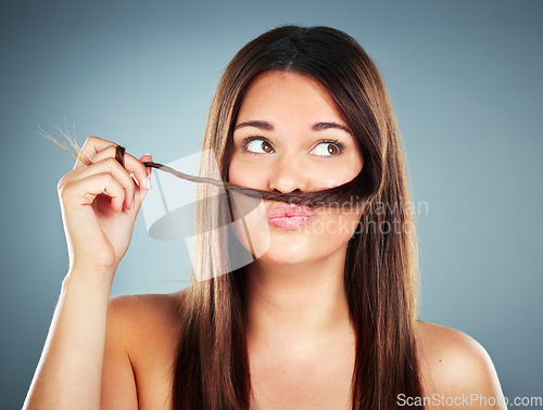 Image of Woman, hair and face of a female with a braid and silly face expression for haircare on a grey studio background. Beauty, cosmetology and brunette with a hair moustache for comic face with hairstyle