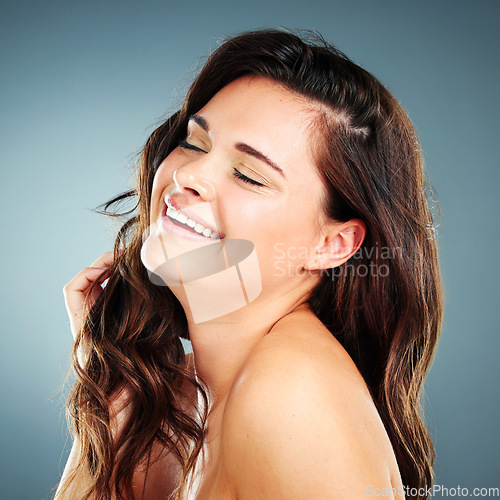 Image of Beauty, skincare and hair care of woman in studio happy about cosmetics, makeup and keratin shampoo for shine and growth. Face of aesthetic model on blue background with glow from dermatology facial