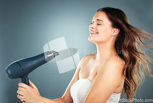 Image of Hair, dryer and woman in studio for beauty, grooming and hair care on a gradient background with mockup. Hairstyle, model and girl relax while styling, blowing and enjoy hygiene, fresh and treatment