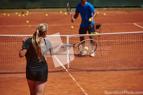 Image of A professional tennis player and her coach training on a sunny day at the tennis court. Training and preparation of a professional tennis player