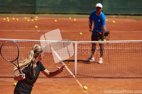 Image of A professional tennis player and her coach training on a sunny day at the tennis court. Training and preparation of a professional tennis player