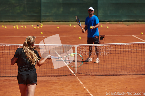 Image of A professional tennis player and her coach training on a sunny day at the tennis court. Training and preparation of a professional tennis player