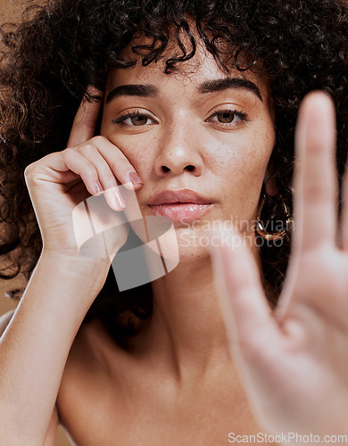 Image of Skincare, hand and portrait of woman in studio for beauty, makeup and glamour skin cosmetic treatment. Portrait, face and black woman serious about hair care, natural hair and luxury afro grooming