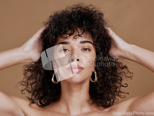 Image of Hair care, black woman and portrait with curly hair, beauty and wellness by cosmetics background. Hair, model and jewelry earrings with cosmetic skin glow with makeup, gold jewellery and radiant face