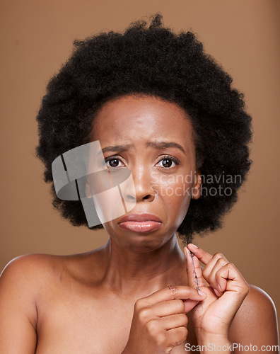 Image of Portrait, hair and black woman in studio for problem, breakage and split ends against a brown background mockup. Afro, face and girl model unhappy with natural hair, tangle and curls with mock up