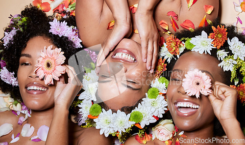 Image of Top view, beauty and black women with flowers for skincare in studio on brown background. Makeup aesthetics, organic cosmetics and group, friends or female models with floral plants for healthy skin