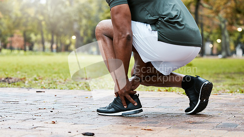 Image of Sports, fitness runner or ankle pain on black man from exercise, training or wellness accident in park, street or nature. Zoom of male athlete health risk, muscle injury from workout while running.