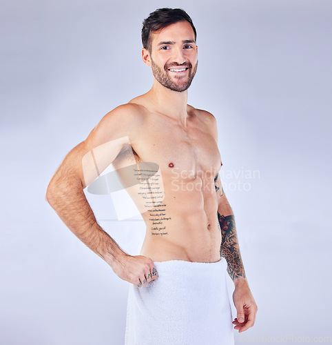 Image of Man, fitness and towel portrait for strong bodybuilder athlete posing on a grey studio background. Athletic, shirtless and abs with a personal trainer and six pack for bodycare, skincare and hygiene