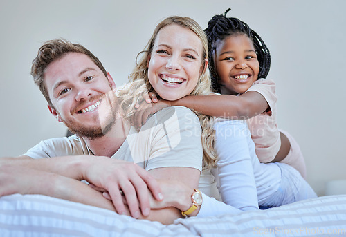 Image of Family, parents and child in interracial portrait on bed with smile, love or happy bonding together in home. Bedroom, multicultural diversity and black girl with foster mom, dad or happy family relax