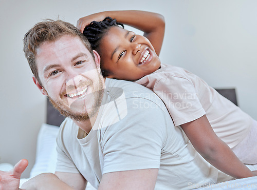 Image of Interracial, father and daughter in bedroom portrait, happy or smile back touch for bonding. Diversity, multicultural family and girl with dad, adoption and bed with laugh, play or comic time in home