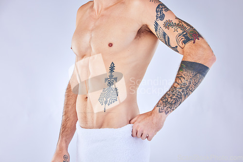 Image of Tattoo, man or stomach in towel in for health, wellness and muscle in studio background with mockup space. Zoom of muscular, skincare and model body ink for six pack, beauty and studio or mock up