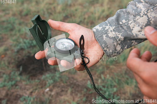 Image of Man with compass in hand outdoor