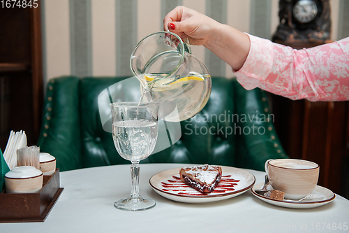 Image of Closeup photo of female hands is reaching out to cake