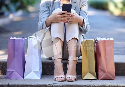 Image of Shopping bag, city and woman on smartphone for e commerce, customer sale and online discount with zoom of shoes or feet. Retail, cellphone and urban street of customer with online shopping app luxury