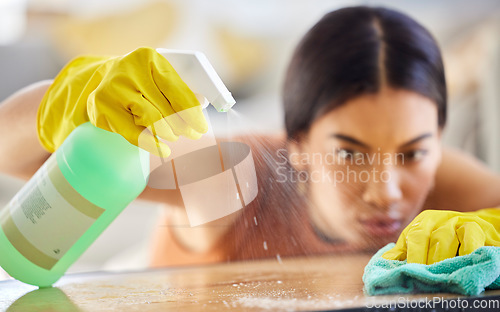 Image of Spray bottle, cloth and woman cleaning table from bacteria, germs or dirt with disinfectant liquid. Housekeeping, hygiene and maid or cleaner with chemical to wipe dust on furniture in home or office