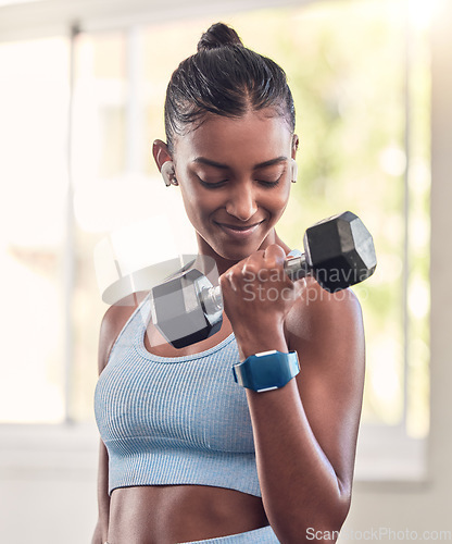 Image of Fitness, exercise and dumbbell with indian woman, earphone and training in a gym for strong health or wellness. Sports, motivation and workout with a female athlete in a sports club for a workout