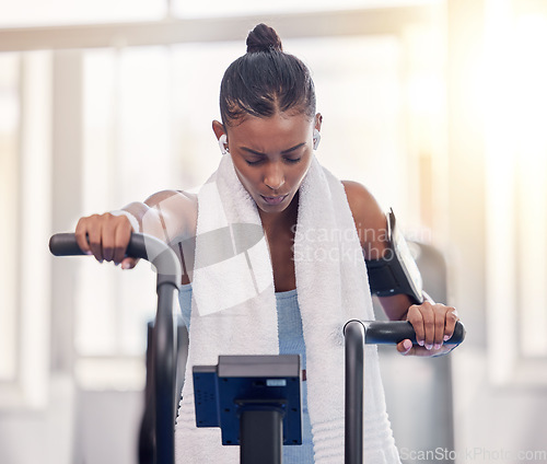 Image of Stationary, bike and fitness black woman in gym for exercise challenge, workout motivation and goal with speed, fast and heart algorithm technology. Cycling machine, sports and Crossfit training girl