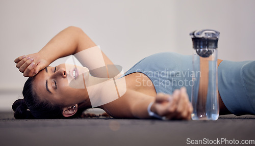 Image of Gym floor, fatigue and woman tired after intense workout, cardio training or yoga fitness exercise. Medical dehydration problem, emergency accident injury and sports athlete faint in pilates studio