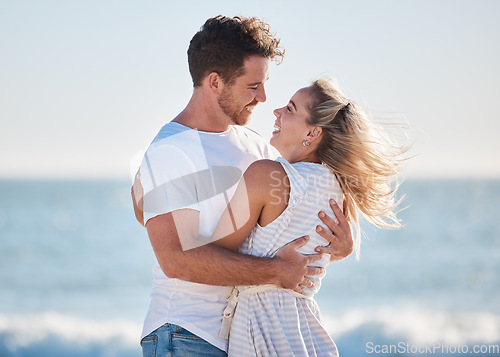 Image of Love, beach hug and couple smile together at the ocean for peace, relax in nature and romance vacation happiness. Happy man, laughing woman and relationship bliss on a travel holiday by sea