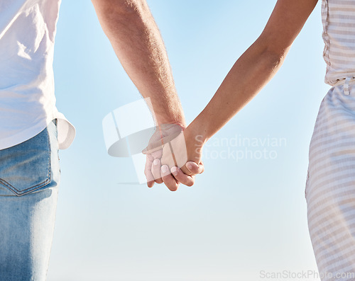 Image of Couple holding hands, blue sky and love together in nature, summer vacation and outdoor for save the date marriage relationship. Closeup hands of man, woman and travel in sunshine, relax and walking