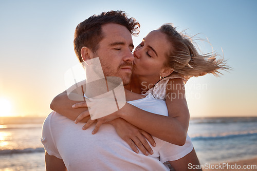 Image of Love, couple and cheek kiss at beach on date, vacation or summer trip. Sunset, affection or romance of man and woman kissing at seashore, bonding and enjoying quality time together outdoors at coast.