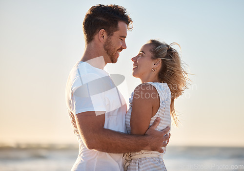 Image of Couple, travel and hug with love and beach holiday, romantic vacation and happy together at sunrise. Man, woman and care with adventure by the ocean, outdoor and nature for bonding and romance.