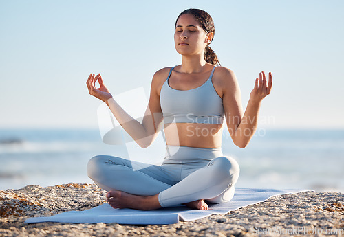 Image of Woman, beach and yoga meditation for mind, body and spiritual wellness in summer sunshine. Girl, fitness or training for zen, mindfulness or peace by ocean, sea or sky for self care, relax or breathe